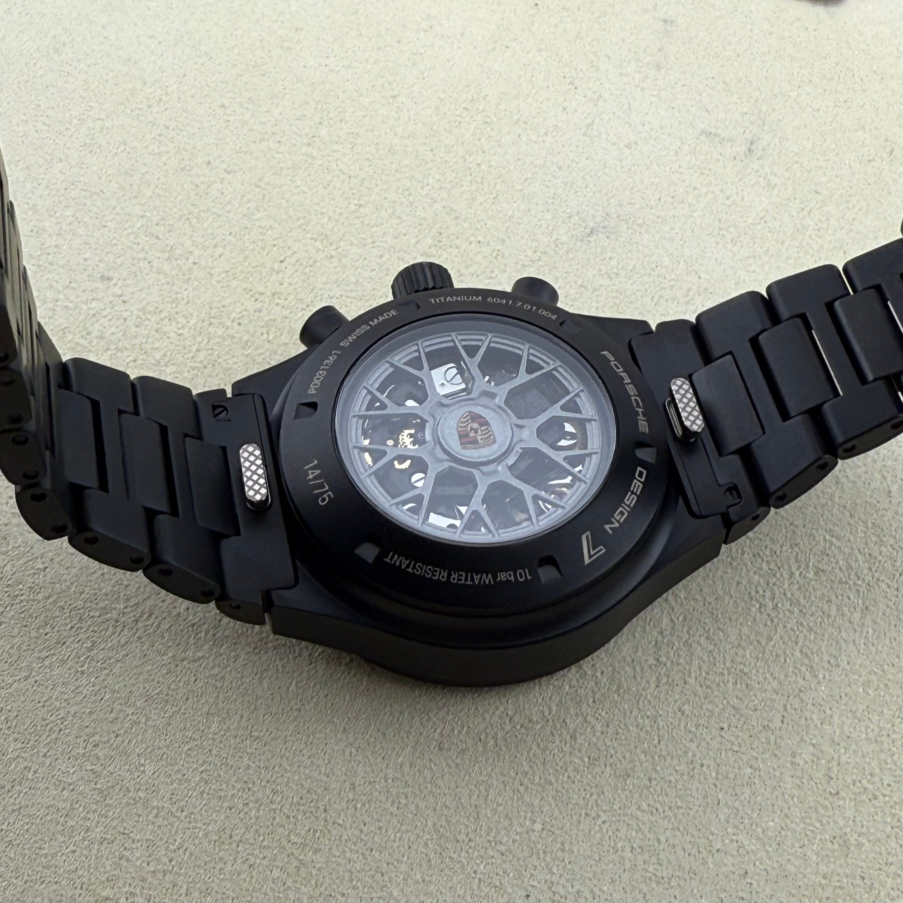 Porsche Design Chronograph 1 Rennsport Reunion 7 Edition Black Titanium Black dial with with white index hour markers and luminous black hands. Three black chronograph sub-dials. Day & date windows at 3 o’clock. Dial 6041.7.01.004.01.5