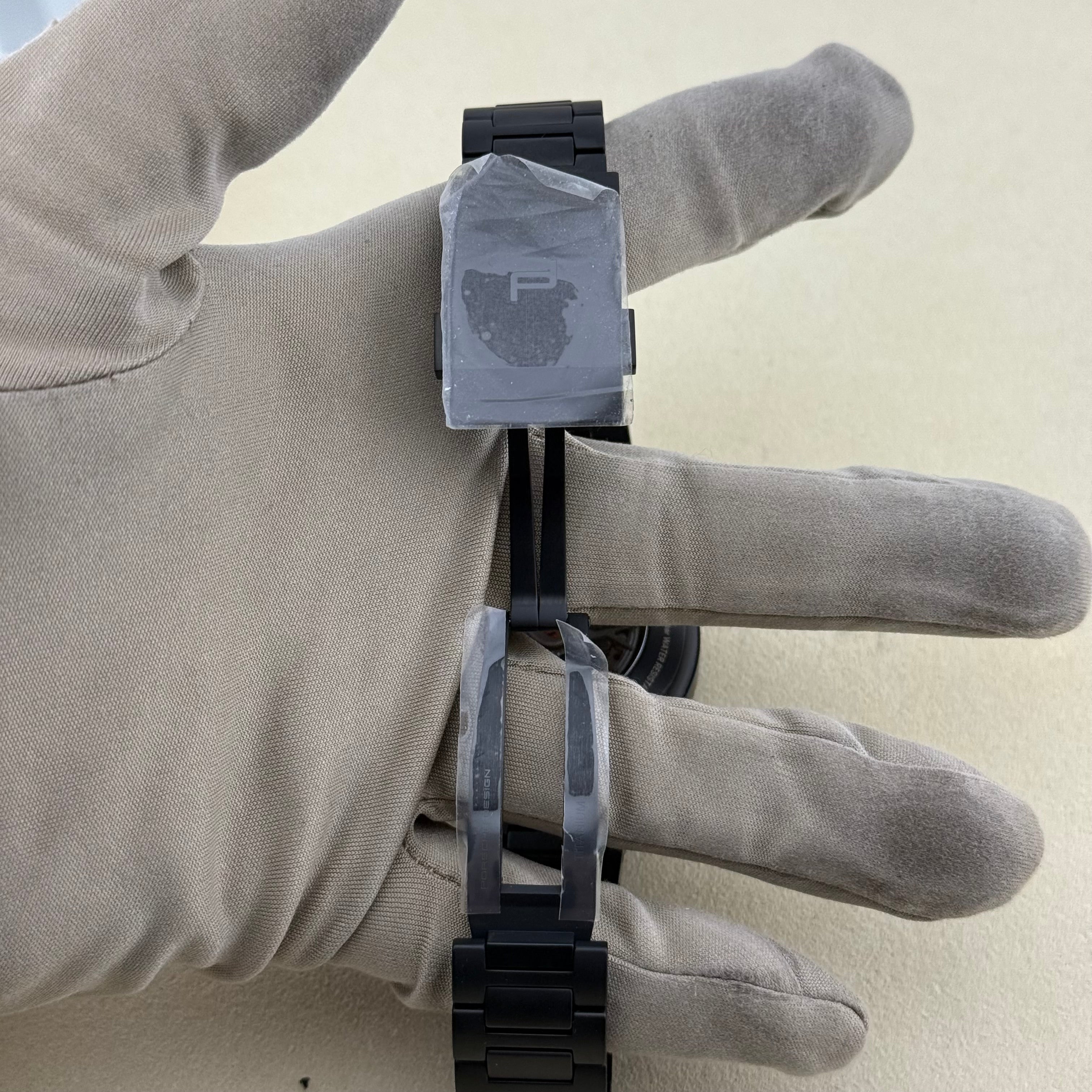 Porsche Design Chronograph 1 Rennsport Reunion 7 Edition Black Titanium Black dial with with white index hour markers and luminous black hands. Three black chronograph sub-dials. Day & date windows at 3 o’clock. Dial 6041.7.01.004.01.5